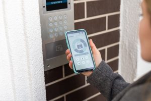 Smiling,Woman,Setting,Home,Security,System,With,Help,Of,Mobile